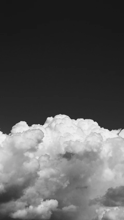 a plane flying through a cloud filled sky