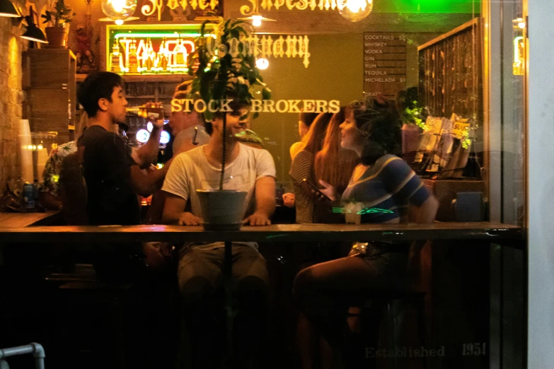 people sit at the bar while one person checks his cell phone