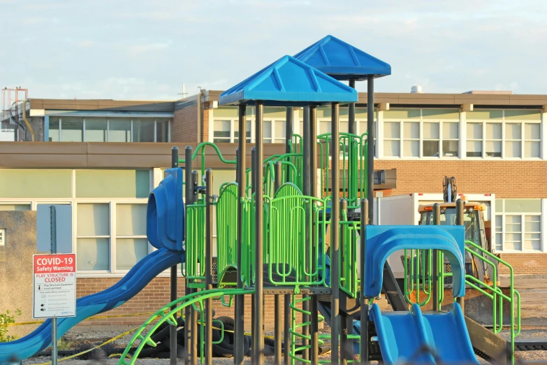 a green and blue playground with several slides