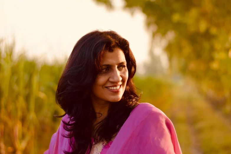 a smiling lady with a pink scarf on