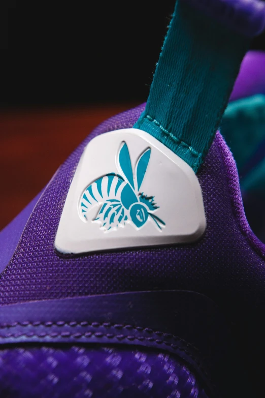 the shoes are adorned with an insect - themed decal