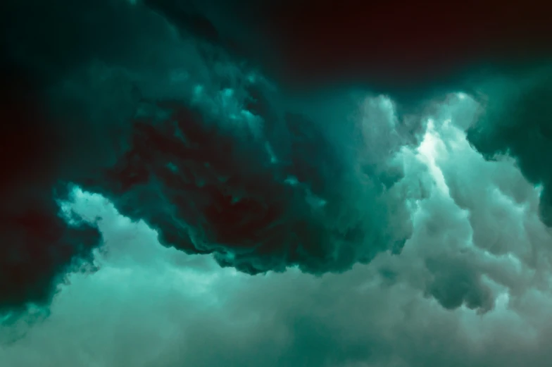 a jet flying through a very cloudy blue sky