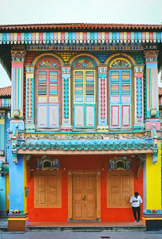a person standing in front of colorful buildings