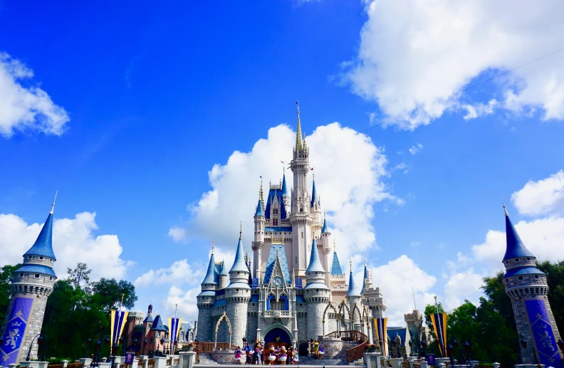 an old castle surrounded by flags in front of blue sky