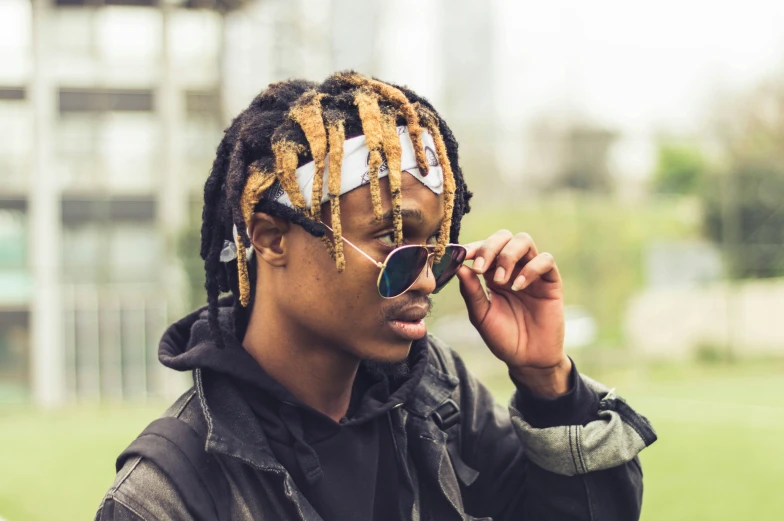 a man with dreadlocks wearing sunglasses on top of his head