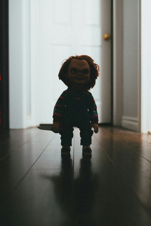 a brown teddy bear sitting on top of a hard wood floor