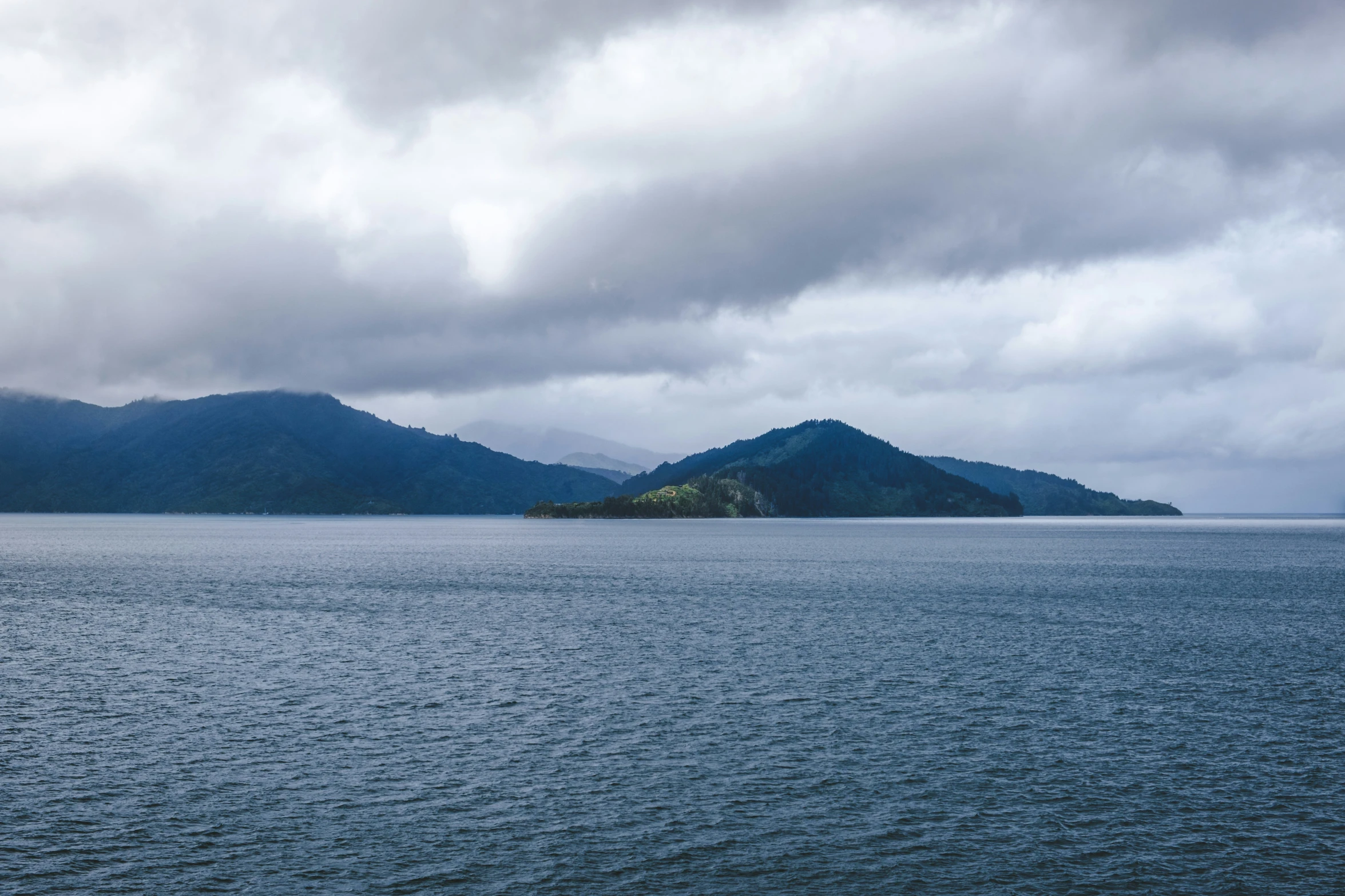 a body of water surrounded by mountain range