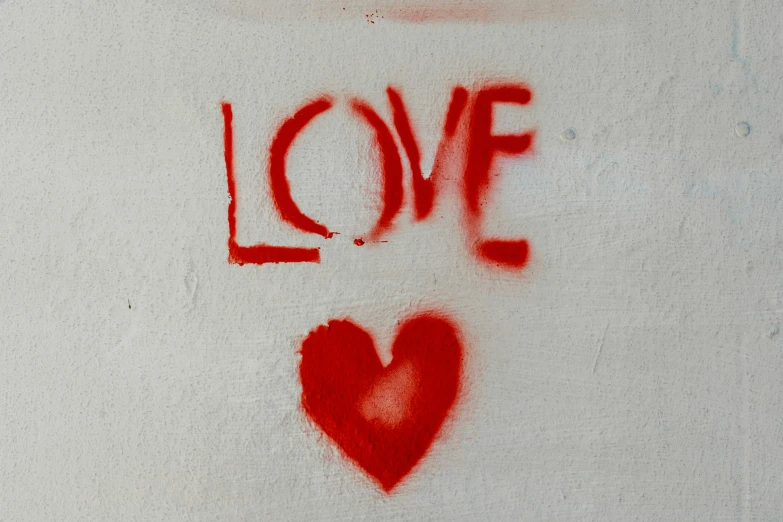 graffiti writing the word love written on a white wall