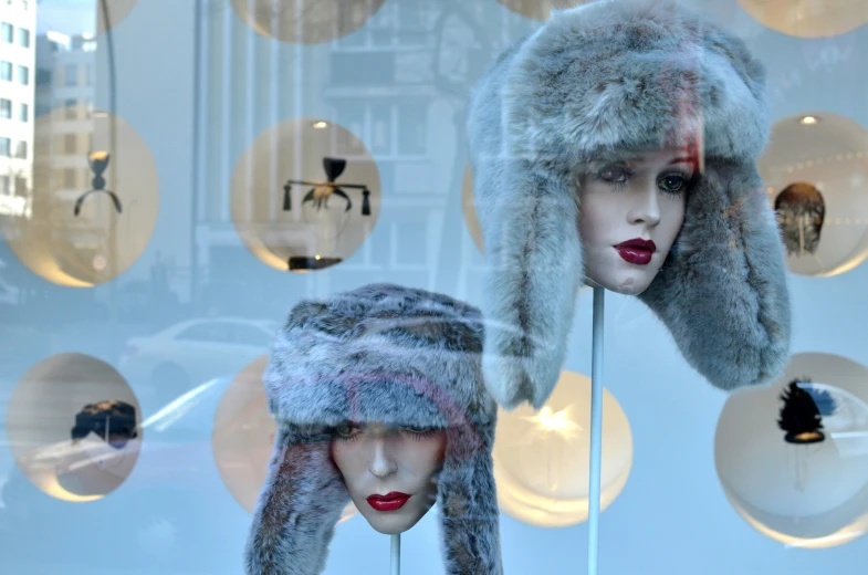 two mannequins with hats in a window display