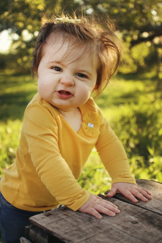 a baby standing on top of a wooden bench