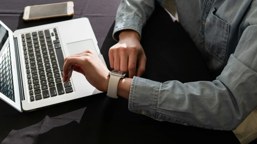 a person typing on a laptop on a table