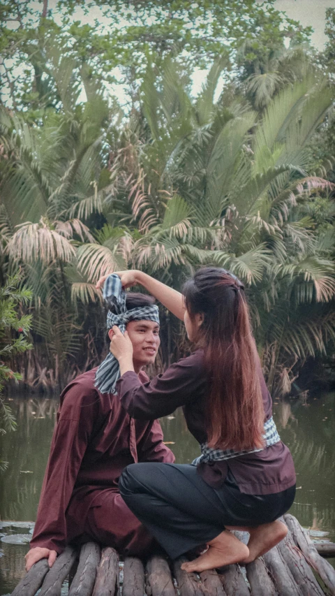 a woman and man are sitting on the dock