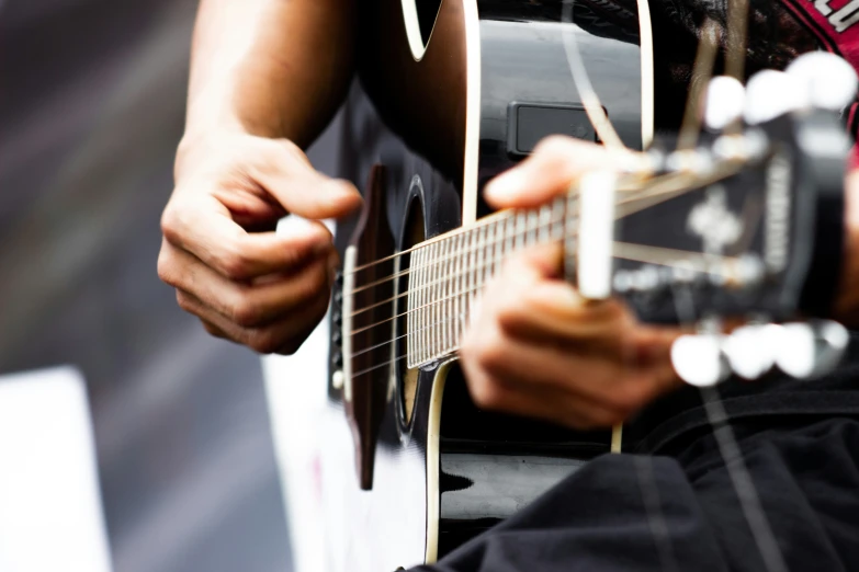 someone is playing a guitar outdoors in the sun