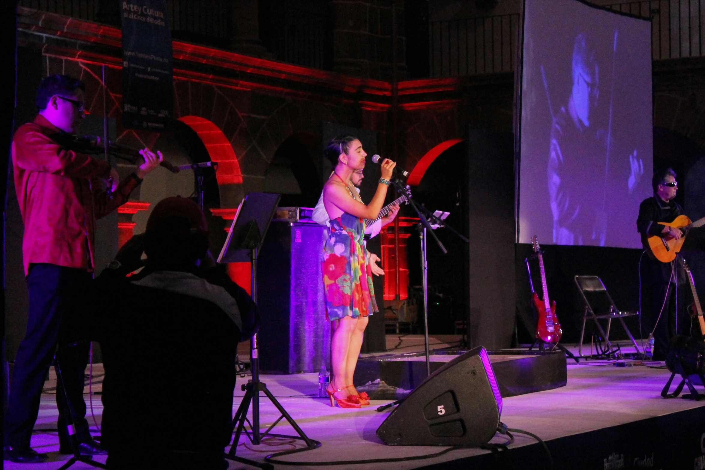 a woman on stage singing in a microphone