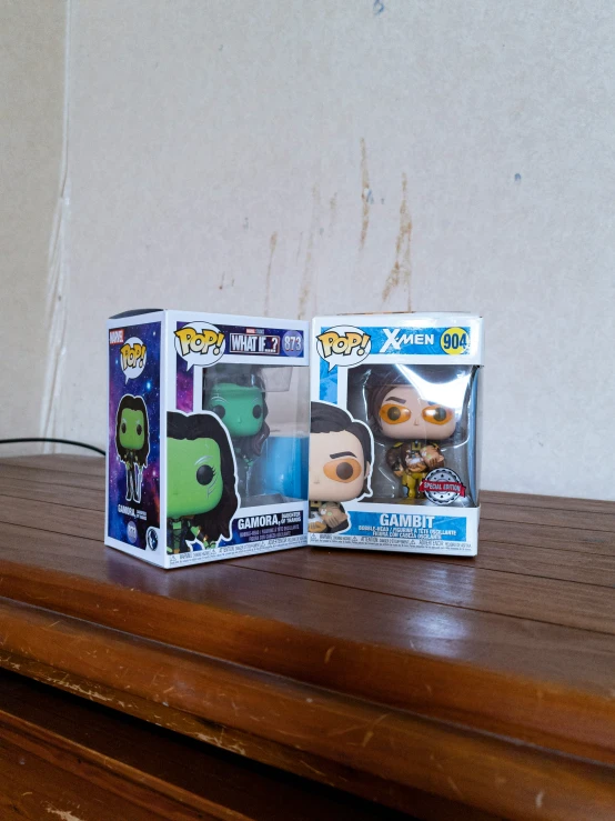 two pop pop vinyls are sitting on top of the wooden table