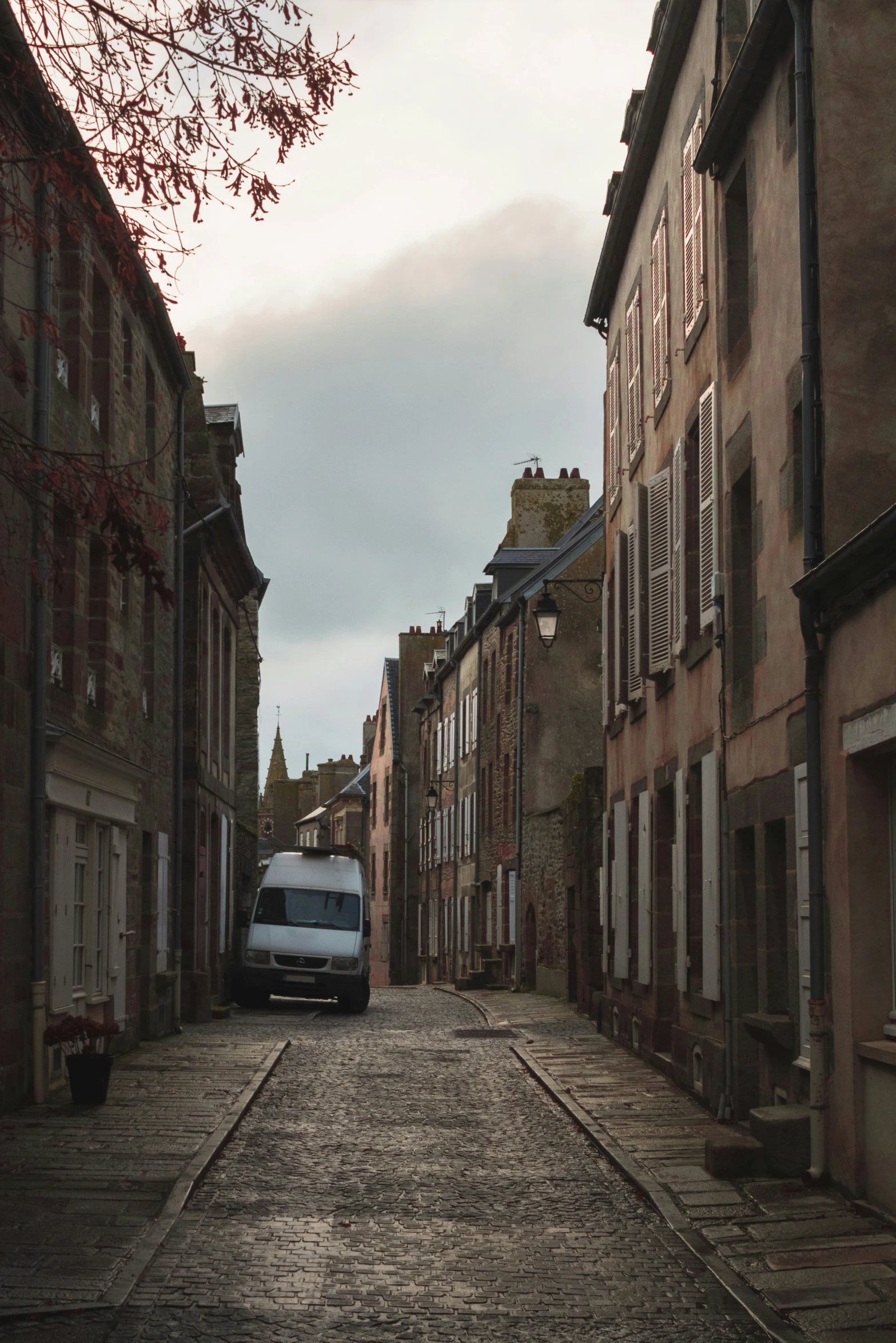 an old street with buildings and cars parked