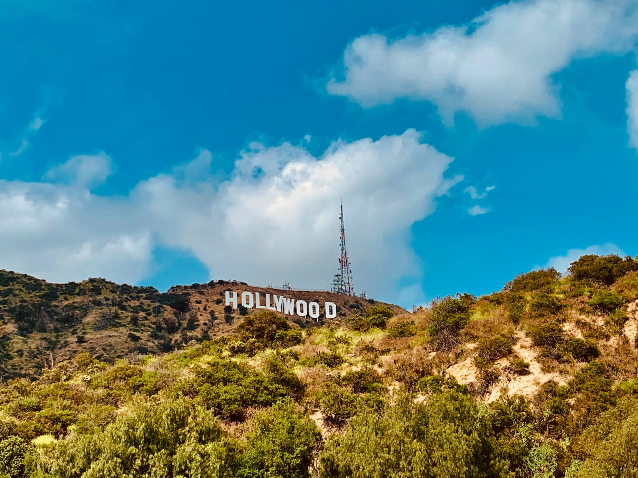 a very tall sign on top of a hill