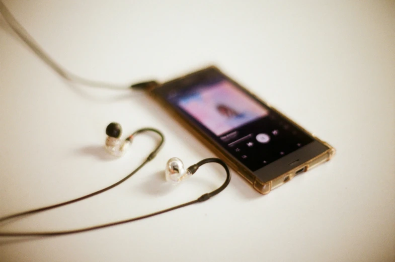 an image of an electronic device with ear buds attached to it