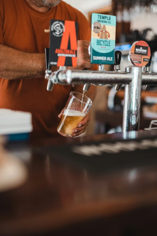 man pouring beer at a tapper in a bar