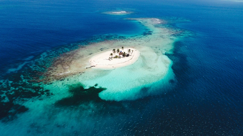 an island surrounded by crystal blue water in the middle of the ocean