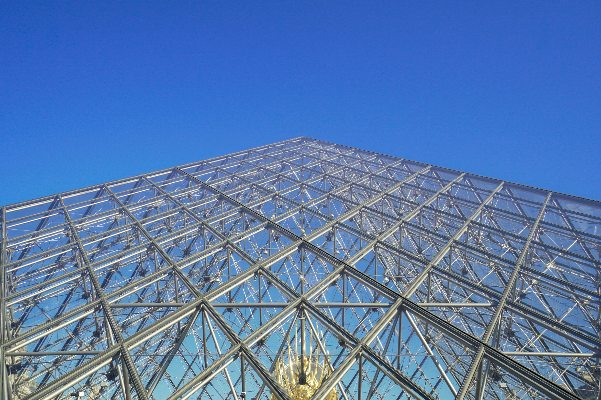 a large glass building in front of a clear blue sky