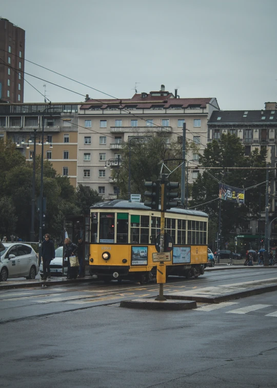 a yellow trolley car on a city street