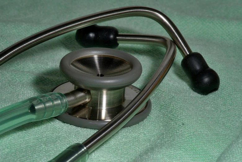 a doctors stethoscope laying next to the cord on a table