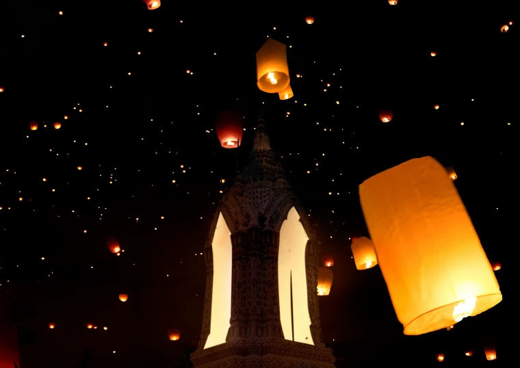 many lanterns being lit at night with stars in the sky