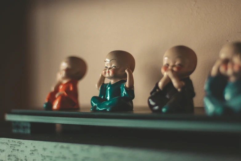 a shelf has four ceramic figurines that are sitting on it