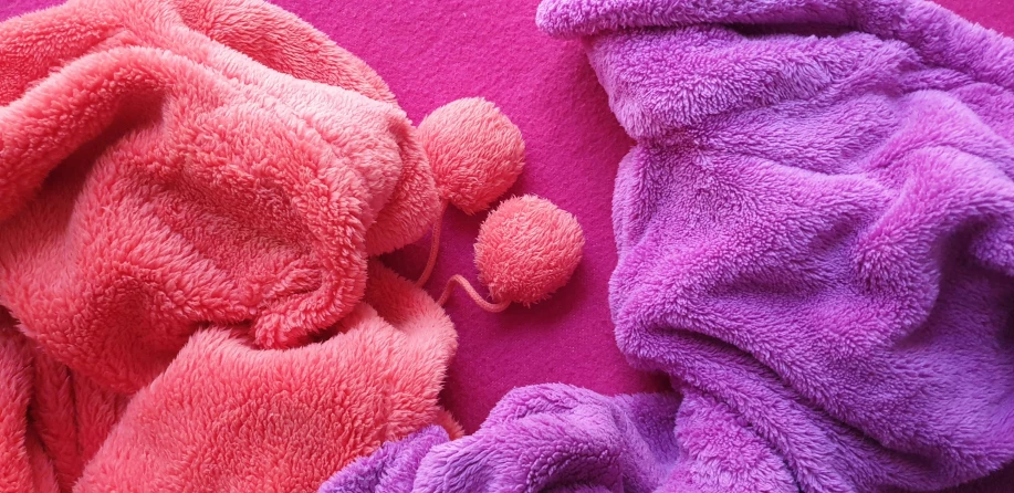 there is a purple and pink elephant next to another towel