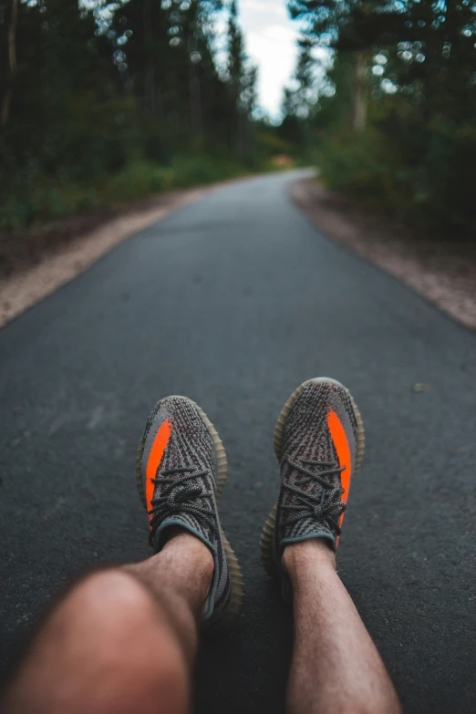 legs with orange sneakers on on the road