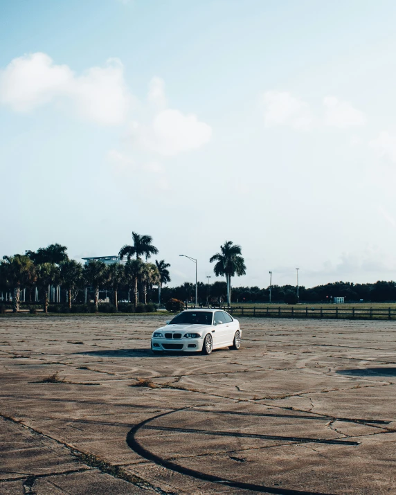 there is a small white car parked in the dirt