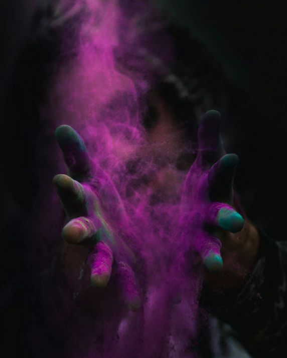man with his hands in purple smoke and his fingers out