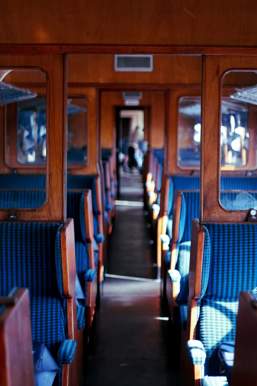 the view of a long bus with blue seats