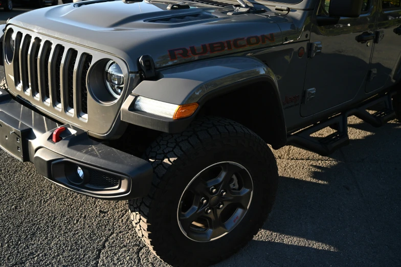 the front grill and tire rim of a grey jeep