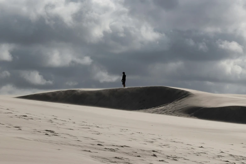 a man is standing on a large dune