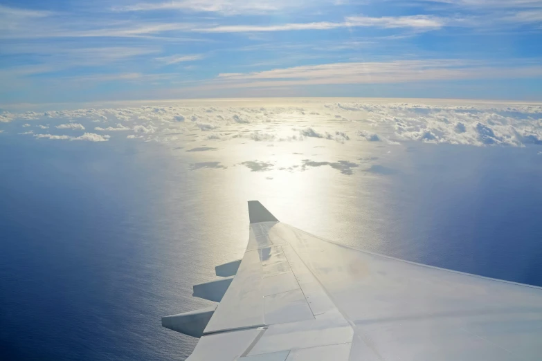 the wing of a jet flying above the ocean