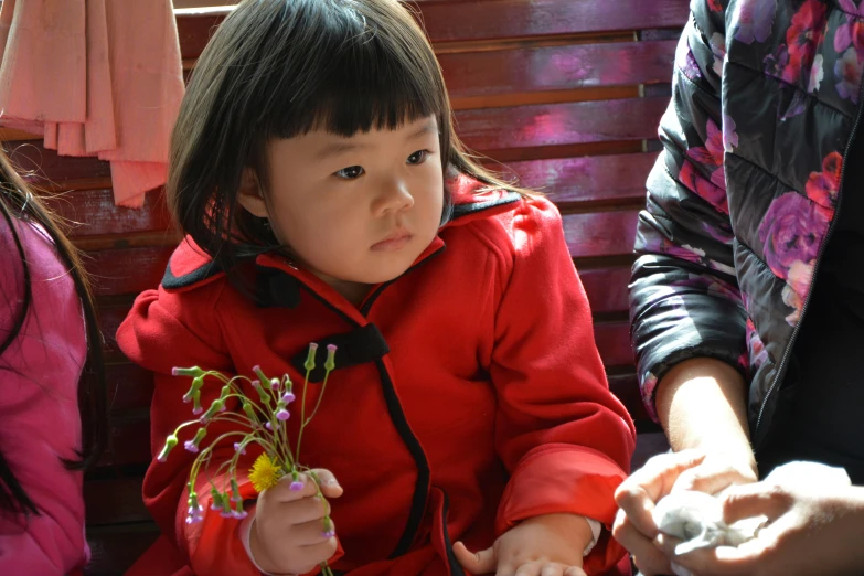 a little girl with red and black jacket on