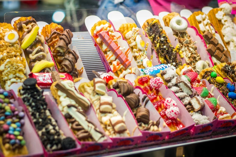 a bunch of assorted desserts are displayed on the shelf