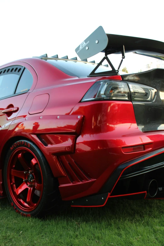 a close up of a red car on the grass