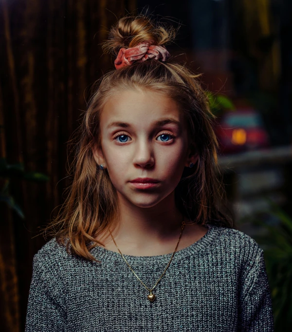 a girl with a ponytail is posing for the camera