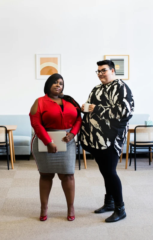 two women posing for the camera in a room with couches