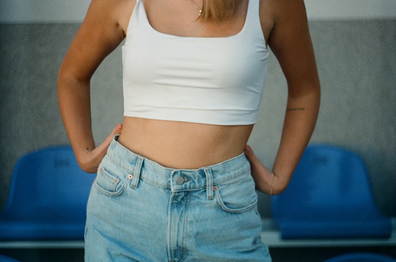 a woman in jeans standing with her hands in her pockets