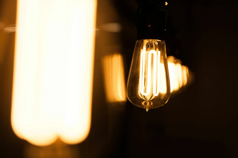 a yellow light bulb sitting on top of a metal pole