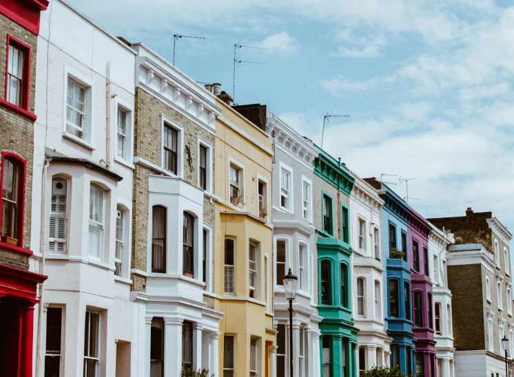 multicolored row houses in europe against blue cloudy sky