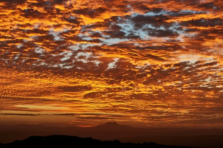 sunset with dramatic clouds and mountains in the background