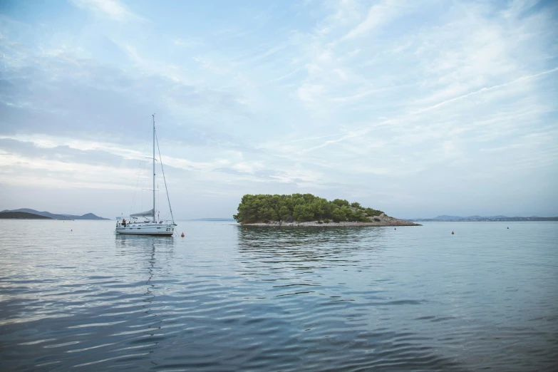 a boat is docked near an island in the ocean