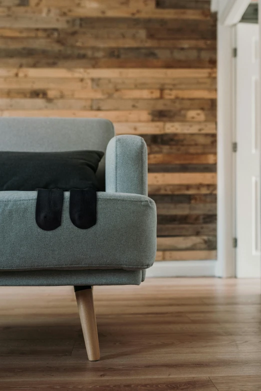 a gray chair sitting next to a wooden wall