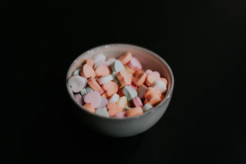 small candy cubes sitting in a bowl on a table