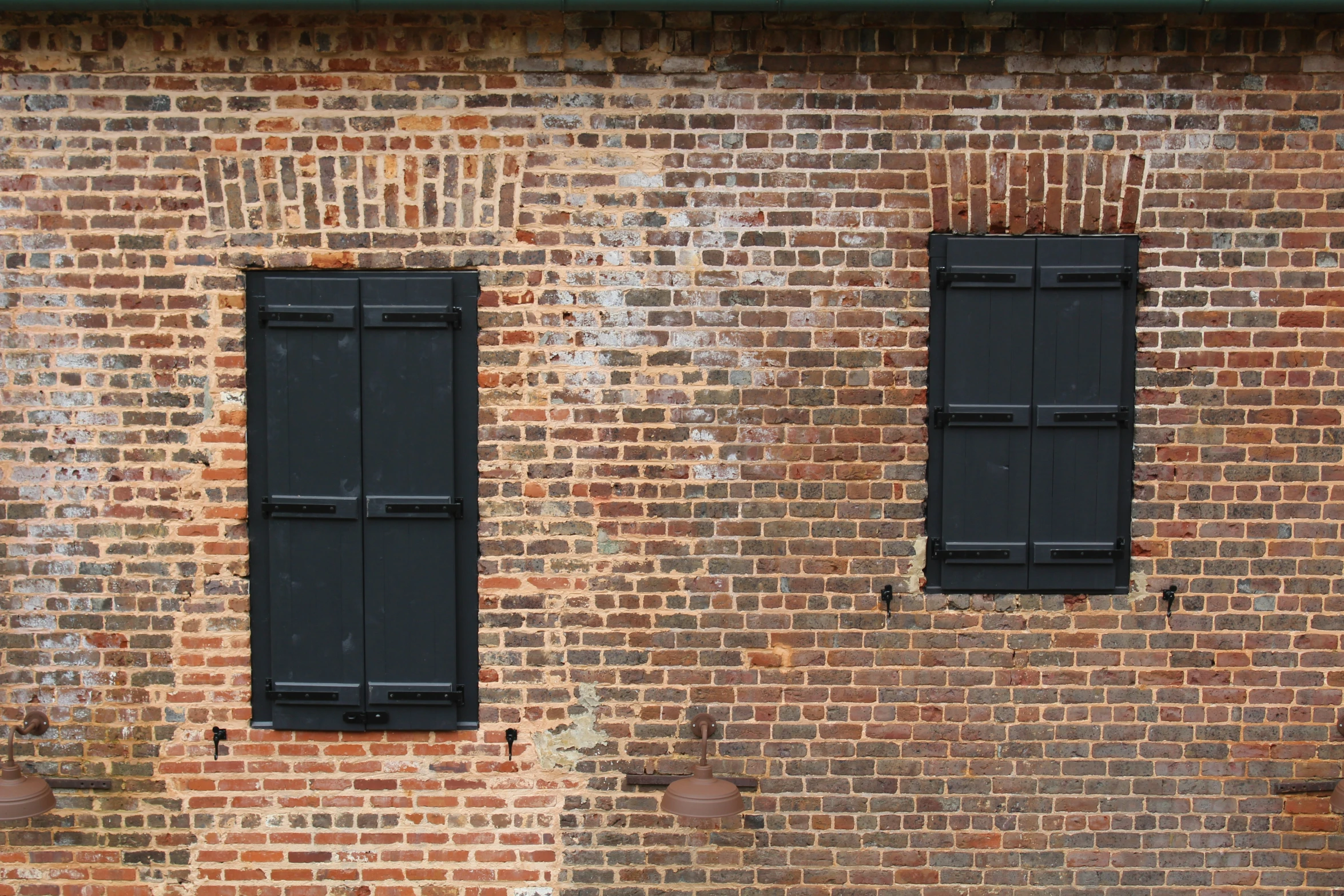 three black windows on a brick building